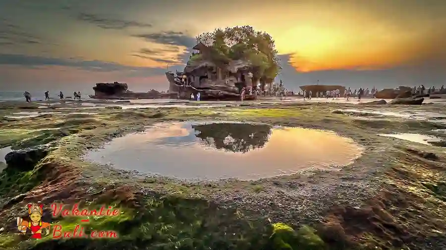 Tanah lot bij laag water en de ondergaande zon. Tanah Lot tempel